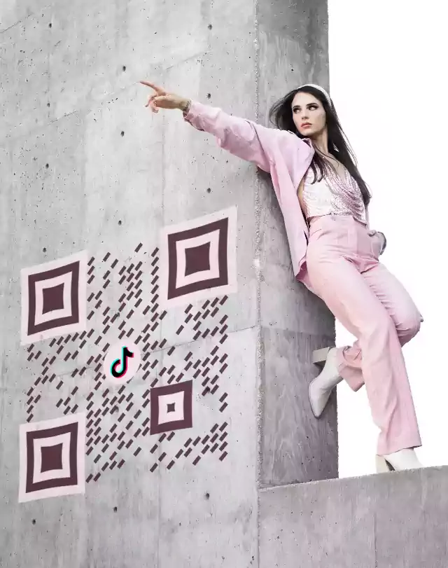 Fashion girl in pink outfit on wall near qr image branded with TikTok logo, made with a QR generator