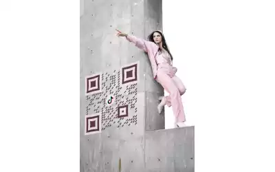 QRcodeLab qr generator - fashion woman in pink outfit on wall with 3D qr image embedding